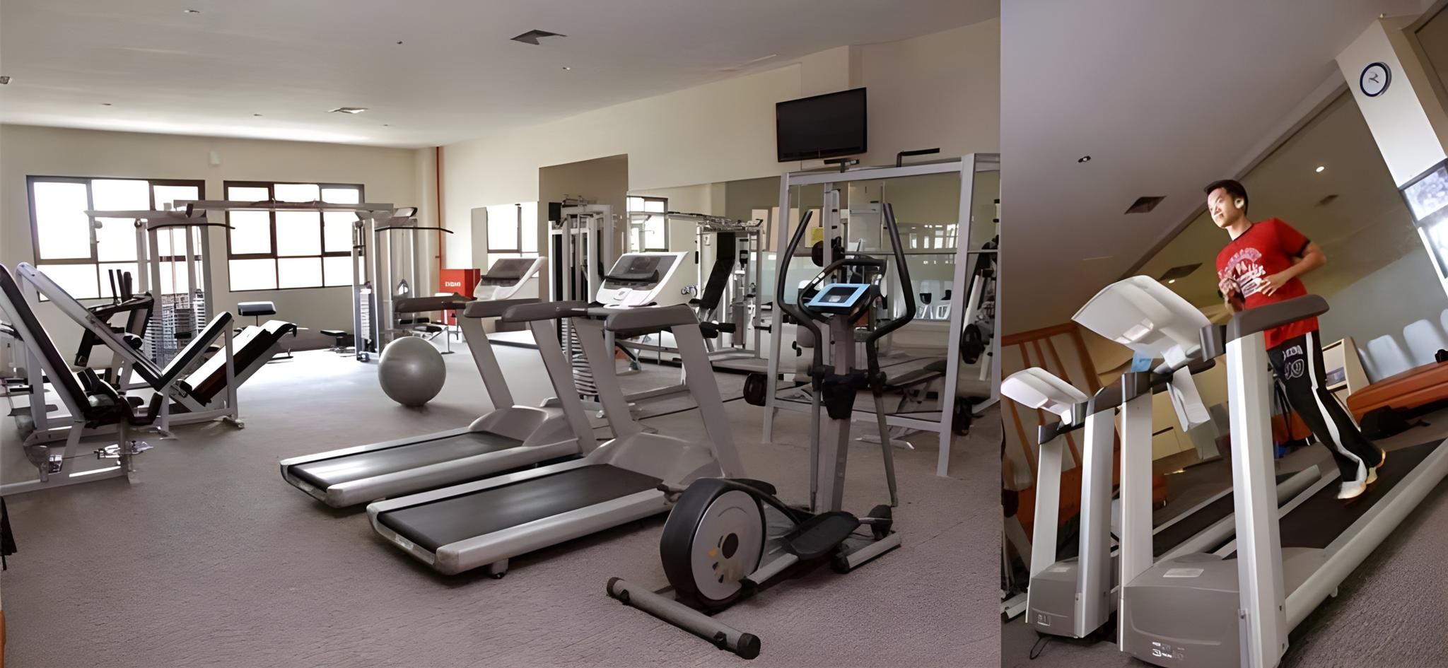 Ein Fitnessstudio mit Laufbändern, Crosstrainern und Gewichten.