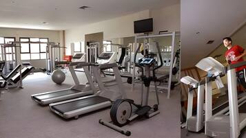 Ein Fitnessstudio mit Laufbändern, Crosstrainern und Gewichten.