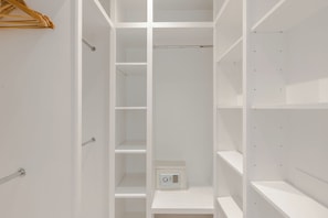 Un dressing avec plusieurs étagères et une porte d’entrée.