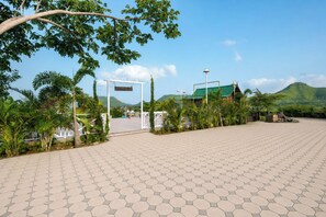 A paved entrance area with a sign reading 'Sierra Vista' and a building with a green roof in the background. - ELIVAAS Signature Sierra Vista Shar Pool (Talegaon Anjaneri)