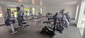 Un gimnàs amb diversos equips d'exercici, incloent cintes de córrer i màquines de musculació.