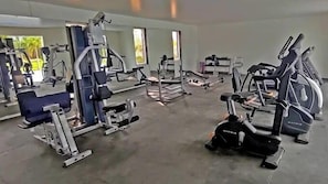A gym with various exercise equipment, including treadmills and weight machines, arranged in a spacious layout. - Fortune Park Airport Road Hubballi (Hubli)