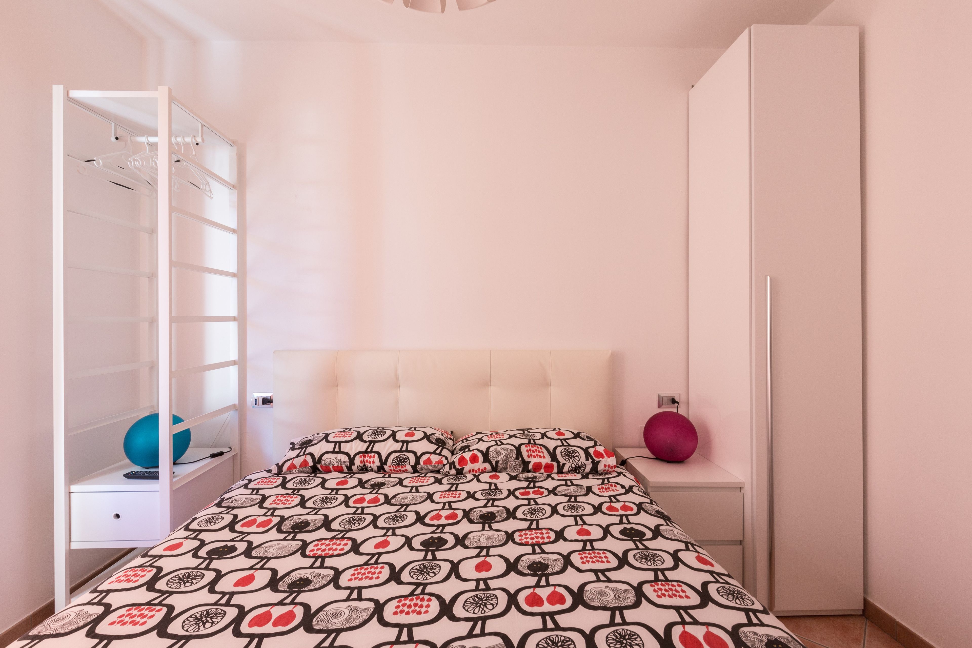 Ein Schlafzimmer mit einem Bett, einem Kleiderschrank und einem Spiegel.