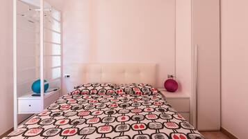 Un dormitorio con cama, armario y espejo.