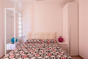 Ein Schlafzimmer mit einem Bett, einem Kleiderschrank und einem Spiegel.