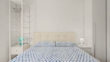 Un dormitorio con cama, armario, mesita de noche y velador.