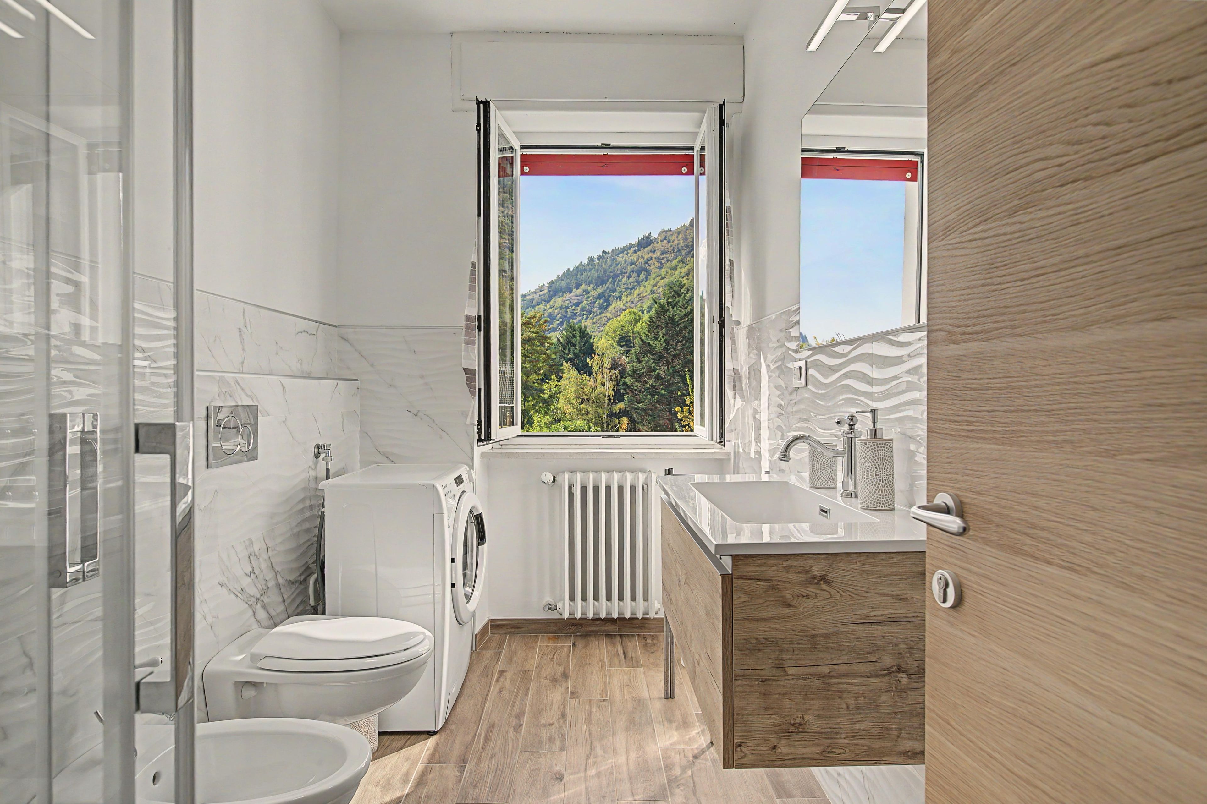Ein modernes Badezimmer mit Toilette, Waschmaschine und Waschbecken.