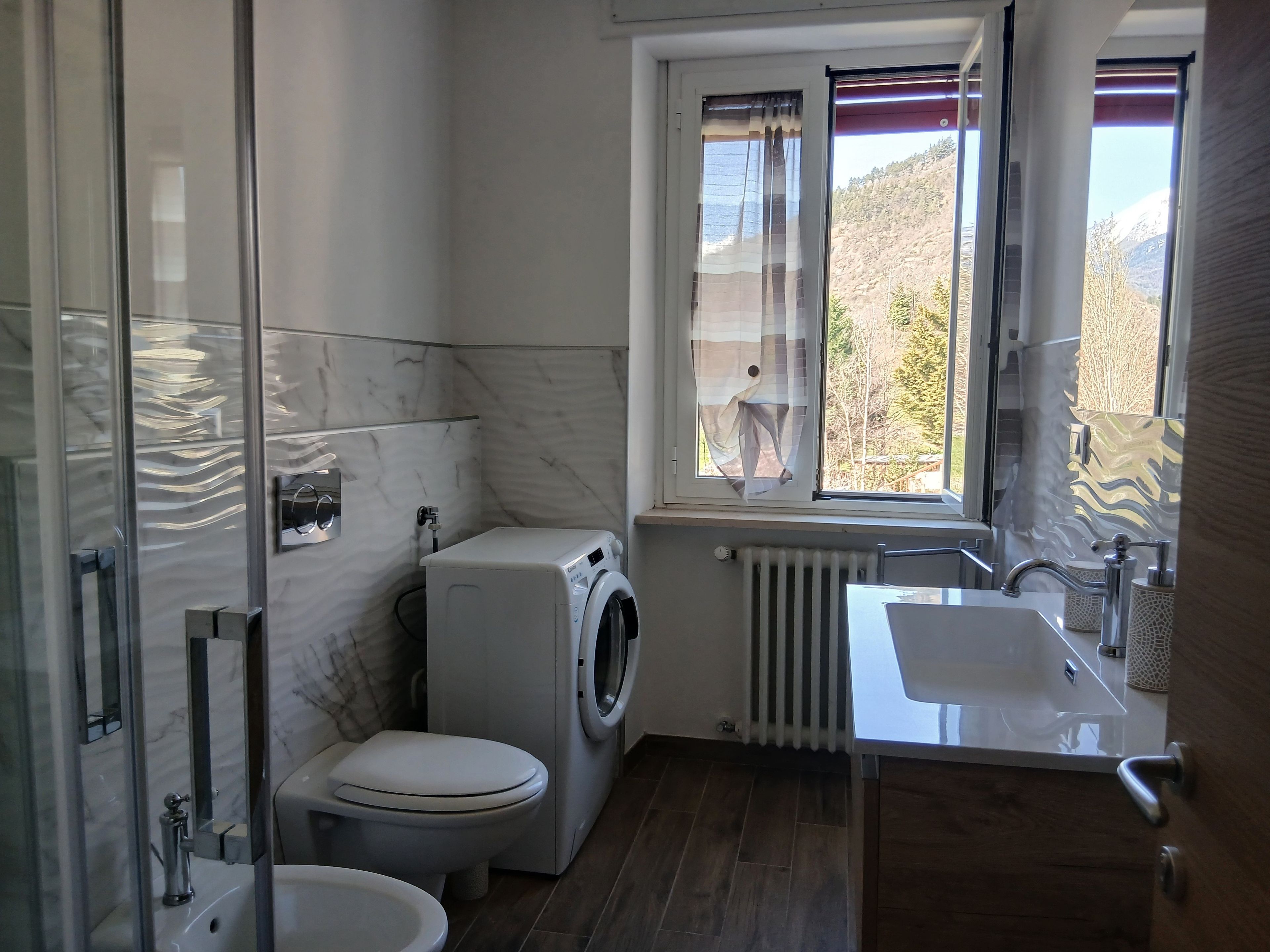 Ein modernes Badezimmer mit Waschmaschine, Toilette und Waschbecken.