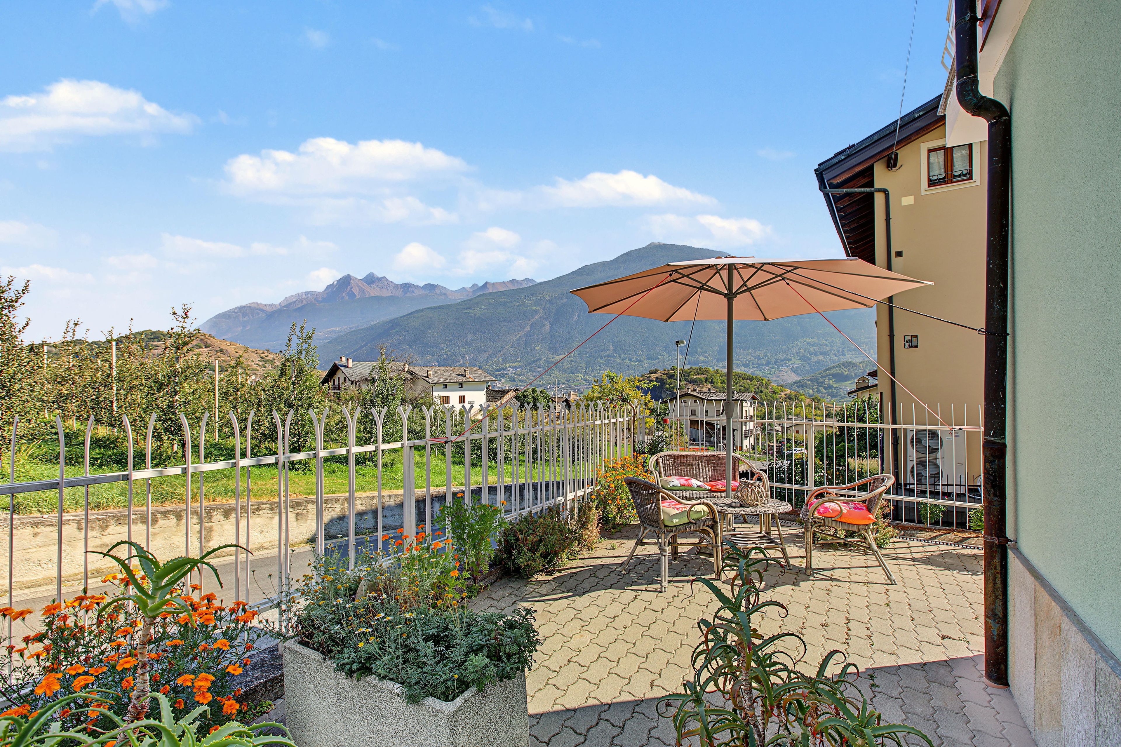 Une terrasse avec des meubles d’extérieur et une vue sur les montagnes.
