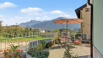 Une terrasse avec des meubles d’extérieur et une vue sur les montagnes.