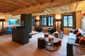 Amplia sala de estar con chimenea, asientos y ventanas grandes que ofrecen vistas.