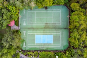 An aerial view of a tennis court surrounded by dense greenery. - Emerald Island Escape | Luxury Stay Near Disney (Kissimmee)