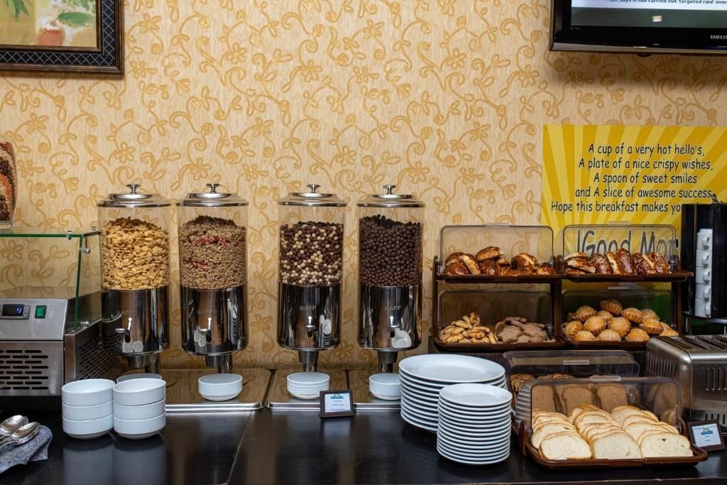 Un buffet de petit-déjeuner proposant une variété de plats et un panneau affichant un message positif.