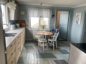 Une cuisine avec une table à manger, des chaises et une fenêtre.