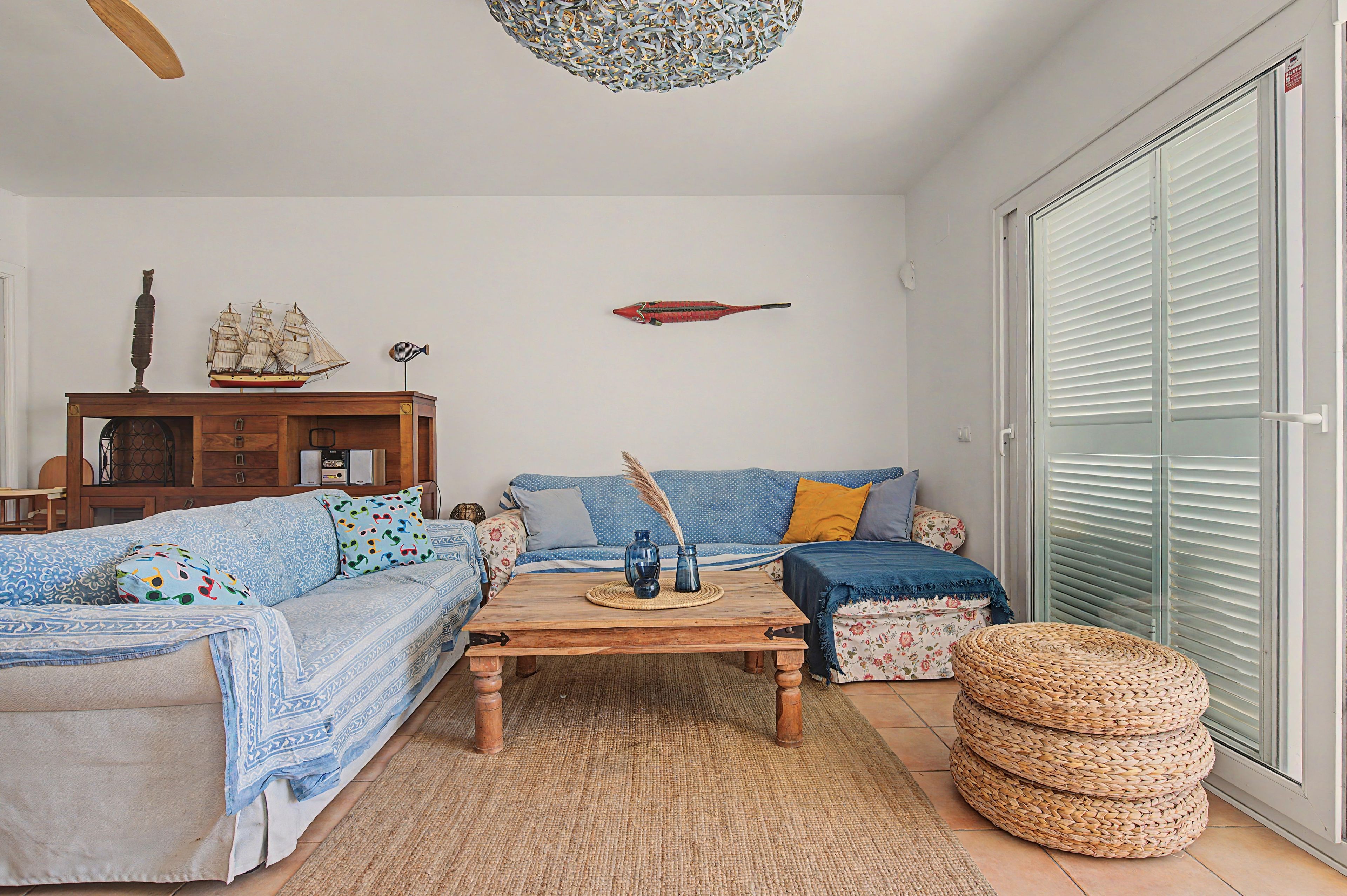 Een woonkamer met een bank, salontafel en decoratieve objecten.