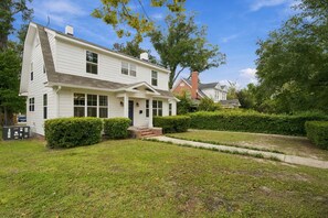 A two-story white house with a front porch, a brick chimney, and a well-maintained lawn. - NEW! Royal Dragonfly - Sleeps 10 - Downtown Wilm. (Wilmington)