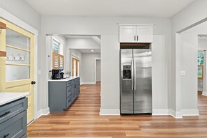 A modern kitchen with a stainless steel refrigerator, wooden cabinets, and a built-in coffee maker. - NEW! Royal Dragonfly - Sleeps 10 - Downtown Wilm. (Wilmington)