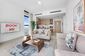 Ein modernes Wohnzimmer mit einer Couch, einem Couchtisch und einem Schild mit der Aufschrift 'BOOK ME' an der Wand.