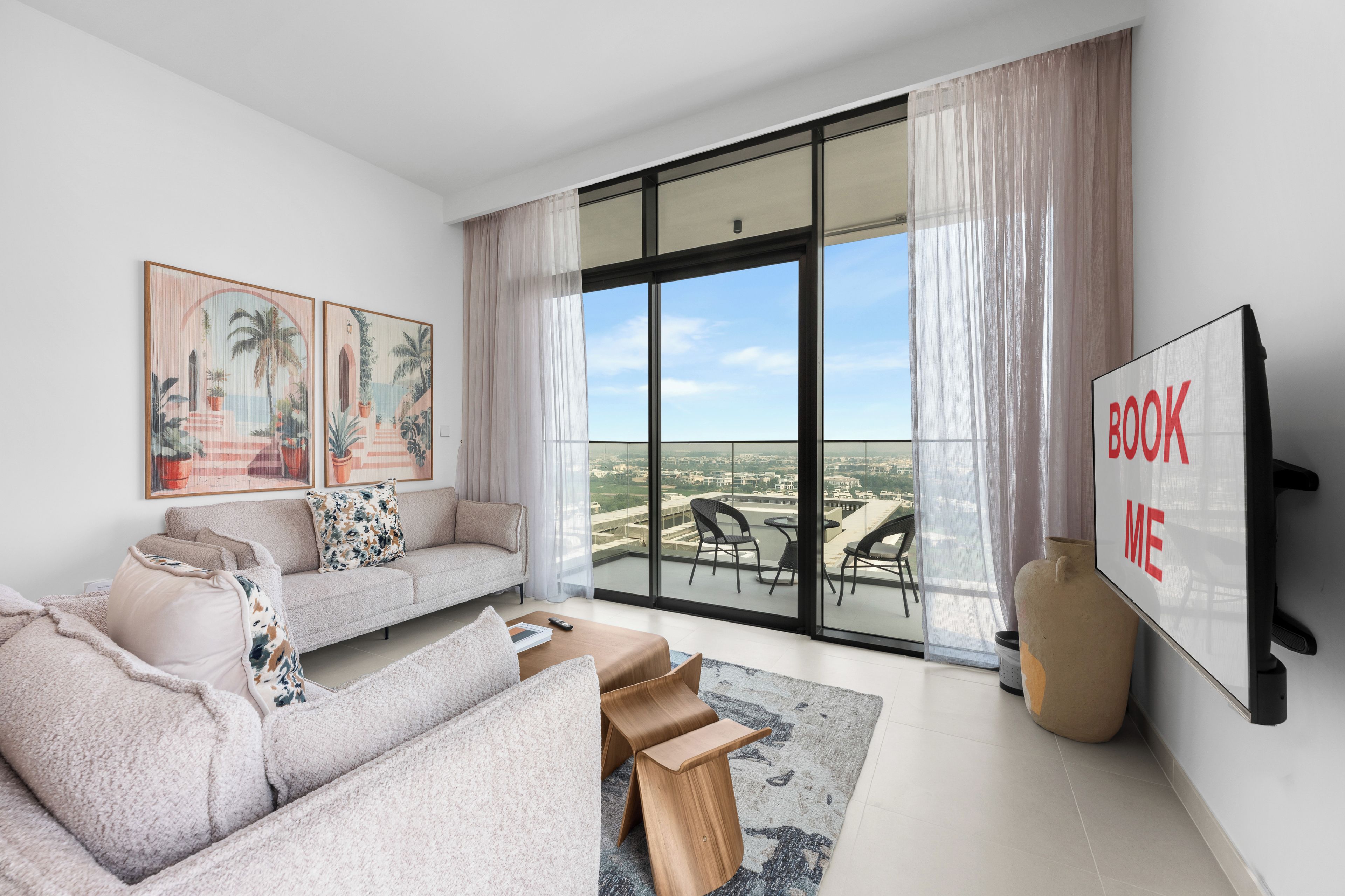 Ein modernes Wohnzimmer mit einer Couch, einem Couchtisch und einem großen Fenster mit Blick auf die Stadt.