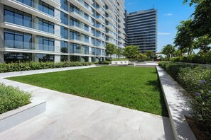 Een modern gebouw met een binnentuin, glazen balkon en heldere lucht.