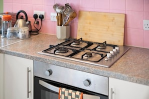 A kitchen with a gas stove, oven, and various kitchen utensils on the counter. - Town centre l 1bd apt l 5 min to station (Hertfordshire)