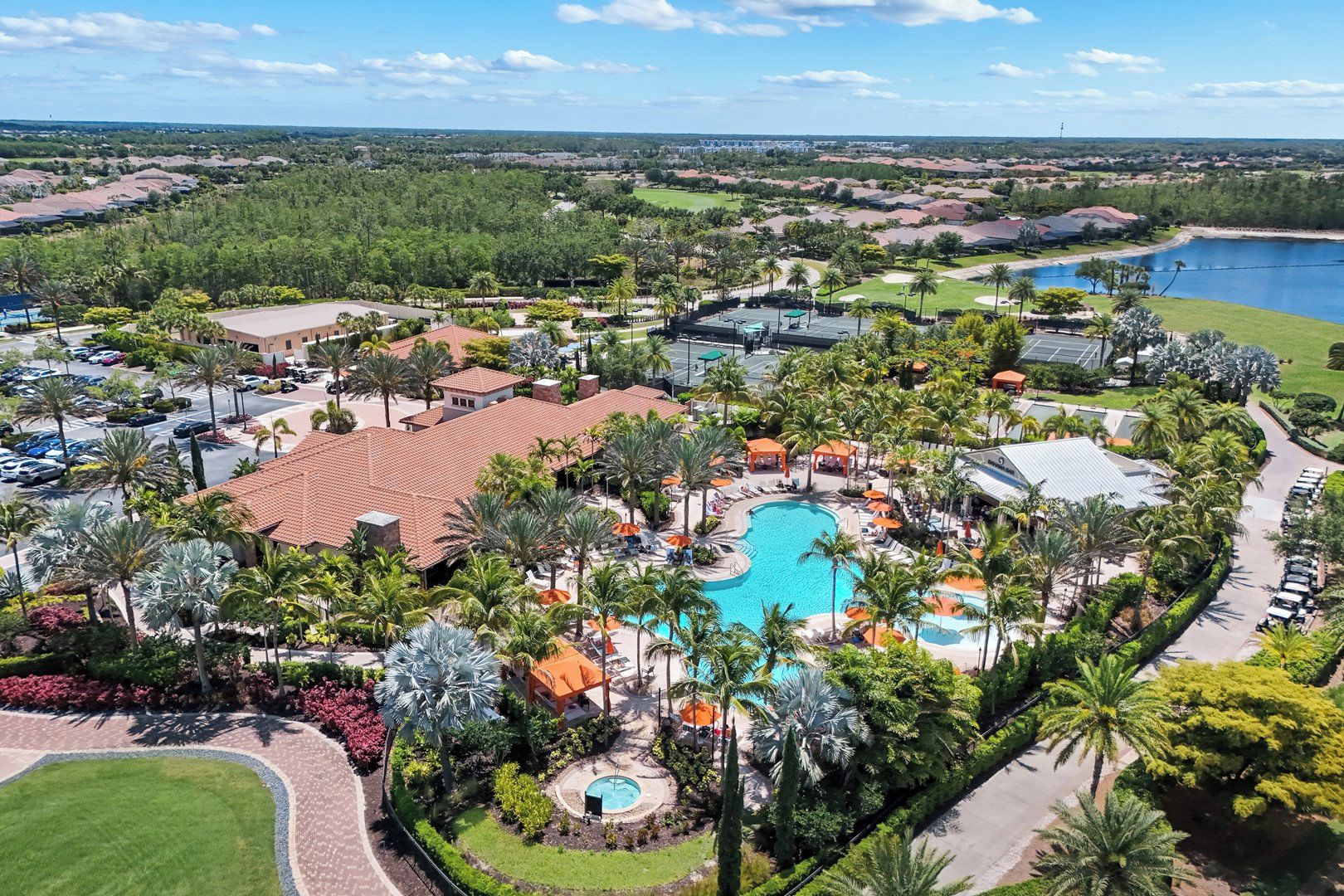 A resort with a central swimming pool, multiple lounge areas, and a view of the surrounding landscape.