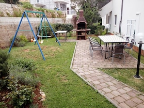 A patio area with a swing set, barbecue grill, and outdoor seating. - Apartments Tomas - One Bedroom Apartment With Balcony (Omis)