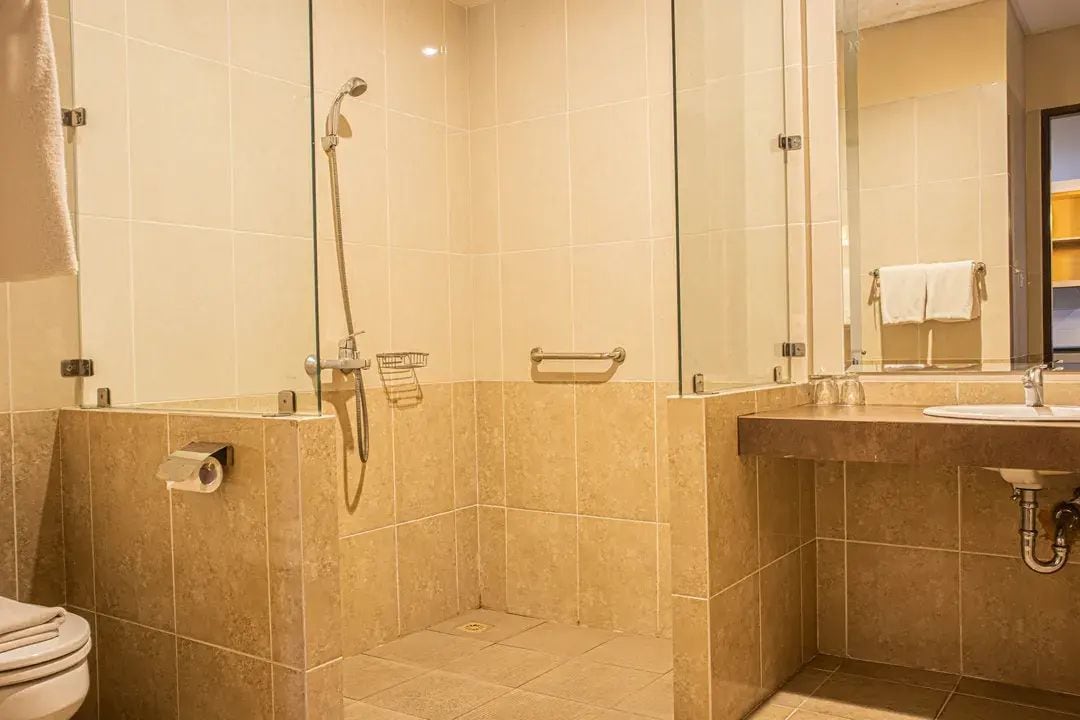 A bathroom with a shower, toilet, and sink.