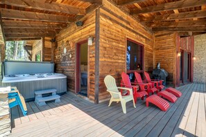 Une cabane en bois dotée d’un bain à remous, d’un espace extérieur aménagé et d’un barbecue couvert.