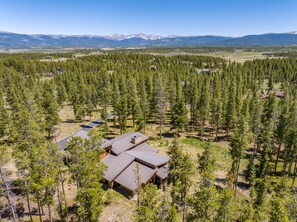 A lodge surrounded by dense forest with a clear view of distant mountains. - Tabernash Retreat | 3BR, Hot Tub, Mtn Views (Tabernash)