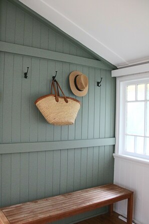 A room with a bench, a wall-mounted hat, and a wall-mounted bag. - Charming cottage in the heart of Maleny. Two minute walk from the main street. (Maleny)