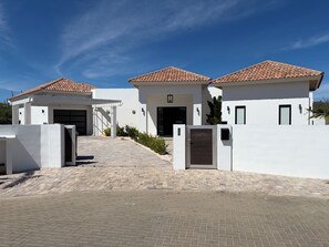 Ein modernes, zweistöckiges Haus mit einem Ziegeldach, einer Garage und einem gepflasterten Einfahrtsweg.