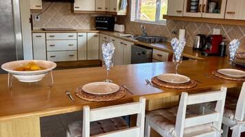 Une cuisine moderne avec un îlot central, des armoires en bois et une grande fenêtre.