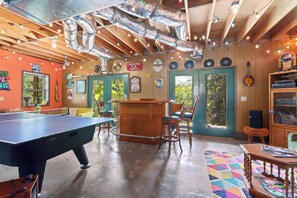 A room with a pool table, bar area, and various decorations including a guitar and framed pictures. - Mountain Views & Fire Pit | Dog-Friendly Cabin (Warne)