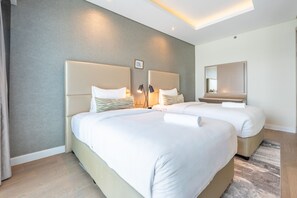 A hotel room with two beds, a large mirror, and a modern light fixture. - Sky Level 2BR with Harbour View, Just a Quick Drive to Downtown AttractionsSky Level 2BR with Harbour View, Just a Quick Drive to Downtown Attractions (Dubai)