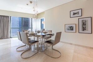 A modern dining area with a round table, chairs, and a large window. - Sky Level 2BR with Harbour View, Just a Quick Drive to Downtown AttractionsSky Level 2BR with Harbour View, Just a Quick Drive to Downtown Attractions (Dubai)