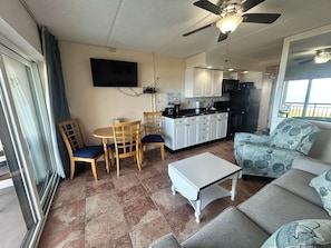 A compact living space with a dining area, kitchenette, and a balcony. - Beacher's Oceanfront Balcony, Condo Complex Construction 10/2026-1/2027 (St. Augustine)