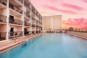 A multi-story hotel with a swimming pool, balconies, and sun loungers. - Beacher's Oceanfront Balcony, Condo Complex Construction 10/2026-1/2027 (St. Augustine)