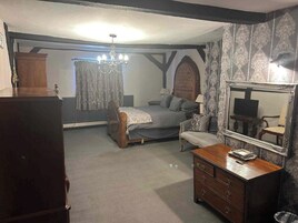 Un dormitorio con cama, cómoda, espejo y una araña.