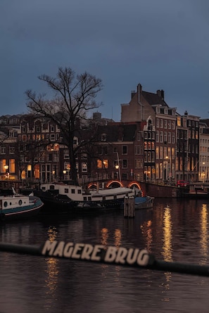 Blick auf das Wasser mit traditioneller Bebauung, einer Brücke und Booten.
