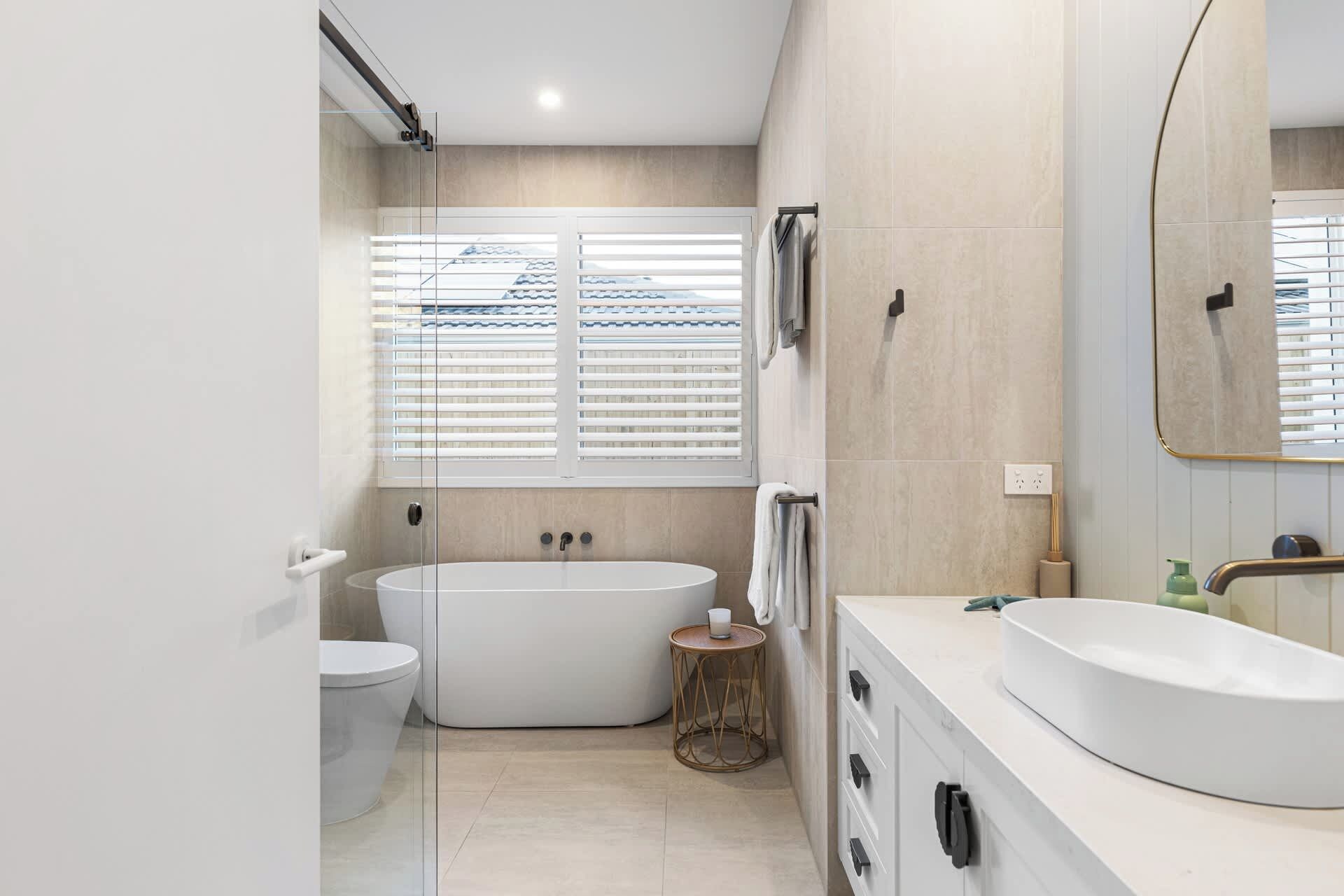 A modern bathroom with a bathtub, toilet, and sink.