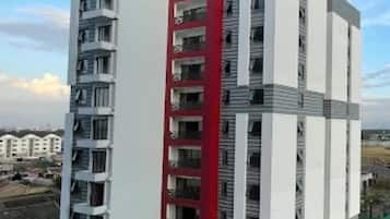 Um edifício residencial de vários andares com uma seção vertical vermelha marcante.