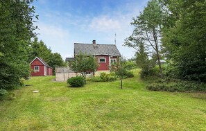 A red house with a sloped roof and a fenced yard. - Stunning home in örkelljunga with WiFi (Örkelljunga)