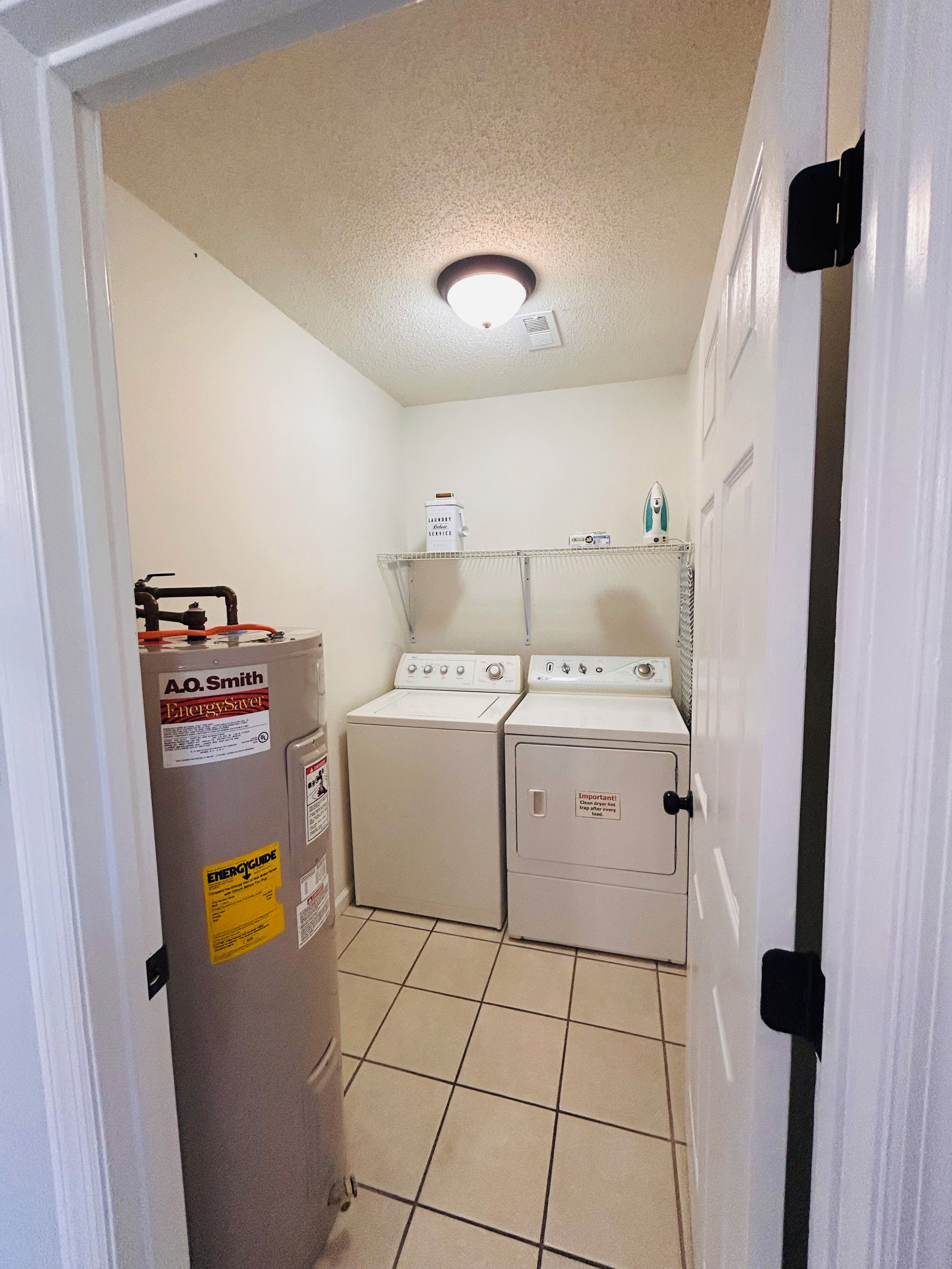 A laundry room with a washer and dryer, a water heater, and a utility room.