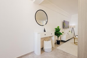 A modern bathroom with a white vanity, a round mirror, a potted plant, and a white cabinet. - Executive Suite 1BR in Kilimani Wifi, Nairobi,views (Nairobi)