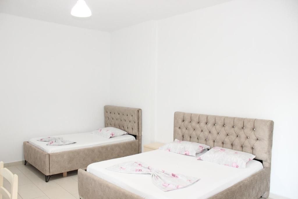 A room with two beds, each with a tufted headboard and floral bedding.