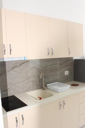 Una cocina con lavamanos, armarios y encimera.