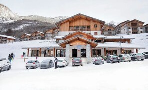 Ein Skigebäude mit mehreren Balkonen und einer Steinverkleidung.