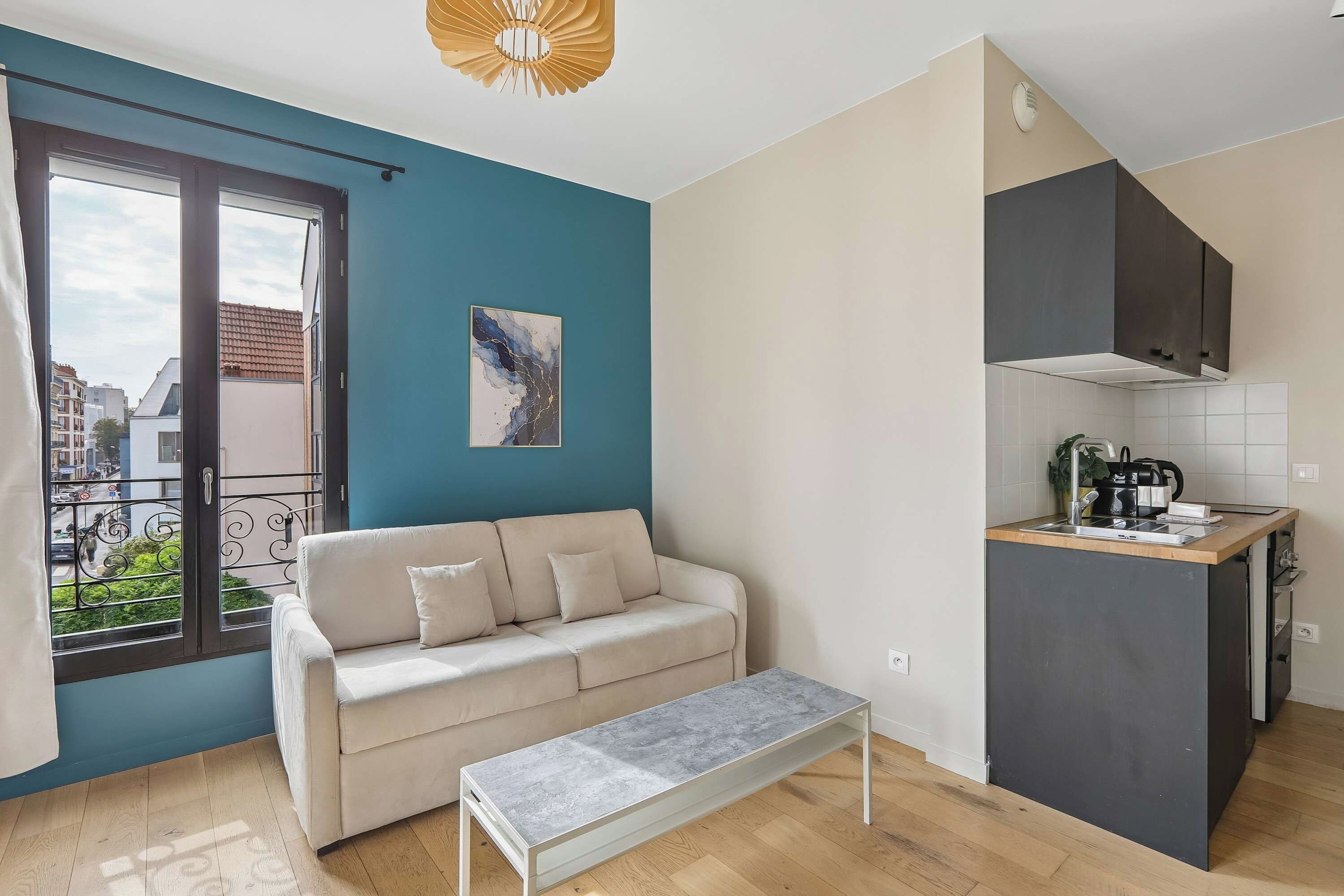 Un apartamento moderno con sofá, banca, cocina y balcón.