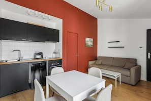 Un espacio habitable compacto con kitchenette, comedor y zona de estar.